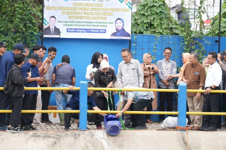 Rektor Unila, Prof Lusmeilia Afriani, ikut menebar ratusan kilogram benih ikan di kawasan Embung D. (foto: ist)